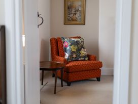 A sitting room with an armchair and a side table at Gatekeepers Cottage near Myddfai Llandovery