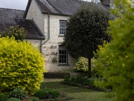 A house with a tree and bushes at Gatekeepers Cottage in Myddfai near Llandovery
