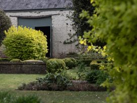 A garden with bushes and a building entrance at Gatekeepers Cottage in Myddfai near Llandovery