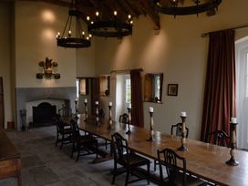 A dining room with a long table and chairs at Gatekeepers Cottage Myddfai near Llandovery