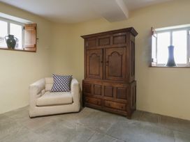 A snug with a chair and a wooden cabinet at North Cottage Llandovery