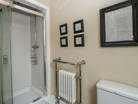 A bathroom with a shower, toilet, and framed art at North Cottage Llandovery