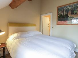 A bedroom with a bed and a painting at North Cottage in Llandovery
