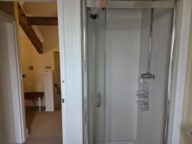 A bathroom with a shower stall and visible staircase at North Cottage Myddfai near Llandovery