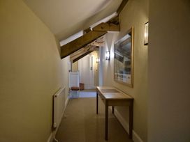 A hallway with wooden beams and a table at North Cottage in Myddfai near Llandovery