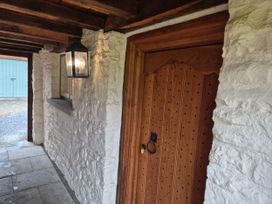 A corridor with a wooden door and a lantern at North Cottage in Myddfai near Llandovery