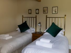 A bedroom with twin beds and a bedside table with a lamp at North Cottage in Myddfai near Llandovery