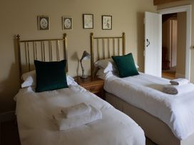 A bedroom with two beds and wall art at North Cottage Myddfai near Llandovery