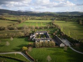 An outdoor view of a farm surrounded by fields and mountains at North Cottage in Myddfai near Llandovery