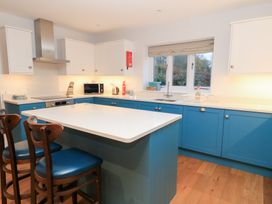 A kitchen with an island and microwave at Peewit Coach House in Moreton-in-Marsh