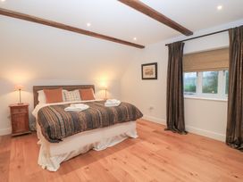A bedroom with a bed and nightstand at Peewit Coach House in Moreton-in-Marsh