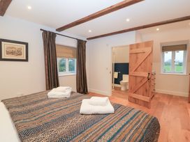 A bedroom with two beds and an en-suite bathroom at Peewit Coach House Moreton-in-Marsh