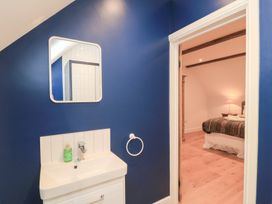 A bathroom with a sink and mirror at Peewit Coach House Moreton-in-Marsh