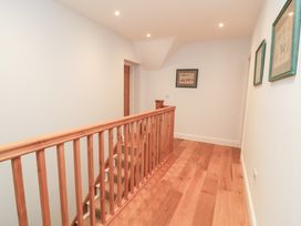 A hallway with a staircase and handrail at Peewit Coach House Moreton-in-Marsh