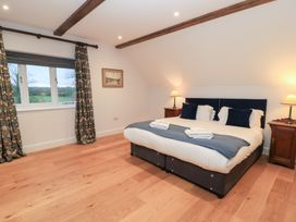 A bedroom with a bed and window at Peewit Coach House in Moreton-in-Marsh