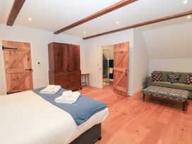 A bedroom with a bed and wardrobe at Peewit Coach House in Moreton-in-Marsh