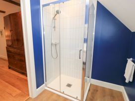 A bathroom with a shower enclosure and a towel at Peewit Coach House in Moreton-in-Marsh