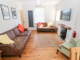 A living room with a sofa and armchair at Hawthorns in Swansea