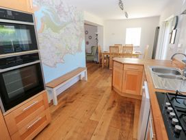 A kitchen with appliances and a dining area at Hawthorns in Swansea