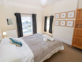A bedroom with a bed covered in blankets and towels at Hawthorns in Swansea
