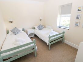 A bedroom with two single beds and a nightstand at Hawthorns in Swansea