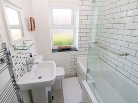A bathroom with a bathtub, sink, and toilet at Hawthorns in Swansea