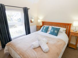 A bedroom with a bed and bedside tables at Hawthorns in Swansea
