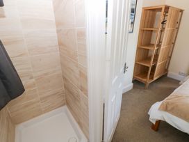 A shower and storage shelf in a bathroom at Hawthorns in Swansea
