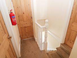 A hallway with a staircase and fire extinguisher at Hawthorns Swansea