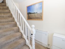 A staircase with a framed picture in the hallway at Hawthorns in Swansea