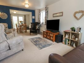 A living room with a sofa and dining area at June Cottage in Wool