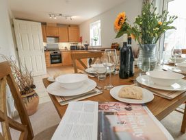 A kitchen with a dining table set at June Cottage in Wool