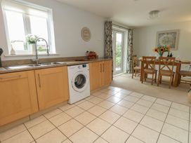 A kitchen with a wash machine and dining table at June Cottage in Wool