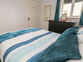 A bedroom with a bed and dresser at June Cottage in Wool