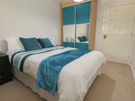 A bedroom with a bed and wardrobe at June Cottage in Wool