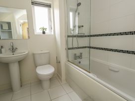 A bathroom with a bathtub, shower, toilet, and sink at June Cottage in Wool