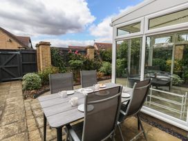 A garden with a dining set and tea cups at June Cottage in Wool