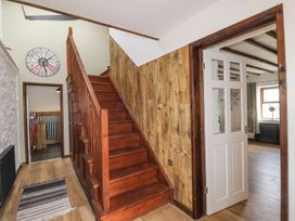 A hallway with a staircase and wall clock at Clawddcam in Mathry