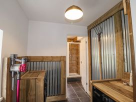 A utility room with a washing machine and a Dyson vacuum at Clawddcam in Mathry