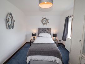 A bedroom with a bed and bedside table at Clawddcam in Mathry