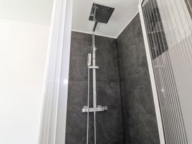 A shower area with a wall mounted shower head at Clawddcam in Mathry