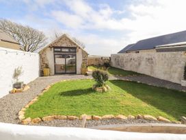 A garden with a gravel path and grass area at Clawddcam in Mathry