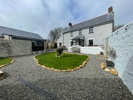 A garden with a lawn and gravel pathway at Clawddcam in Mathry