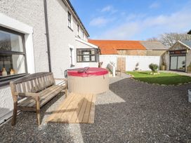A garden with a hot tub and a bench at Clawddcam in Mathry