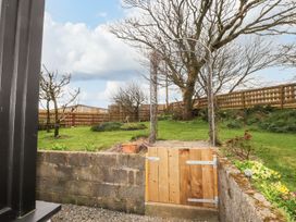 A garden with a wooden gate and archway at Clawddcam in Mathry