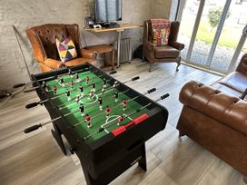 A living room with a foosball table and seating at Clawddcam in Mathry