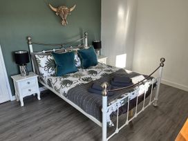 A bedroom featuring a bed with pillows and a bedside table at Clawddcam in Mathry