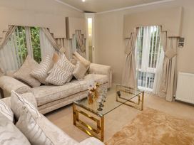 A living room with a sofa and coffee table at The Chalet at Tyn Lon in Chwilog