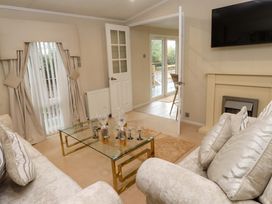 A living room with a sofa and coffee table at The Chalet at Tyn Lon in Chwilog