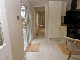 A kitchen with sliding doors and cabinets at The Chalet at Tyn Lon Chwilog